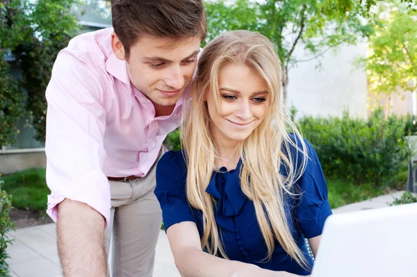 Retrato de una feliz pareja profesional joven utilizando el ordenador portátil —  Fotos de Stock