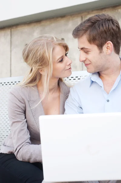 Porträtt av en lycklig ung professionell par med laptop — Stockfoto