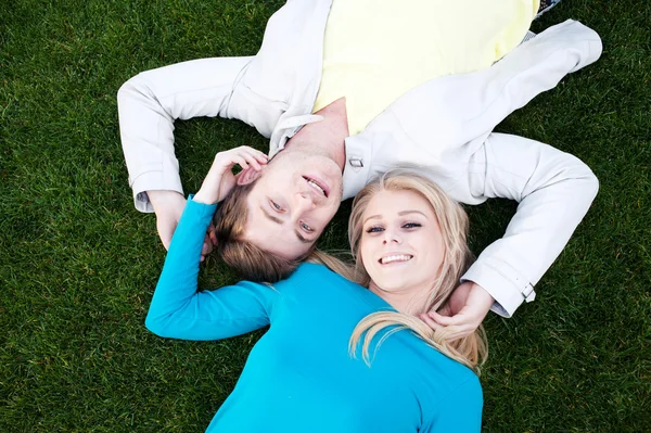 恋に草で横になっている若いカップル — ストック写真