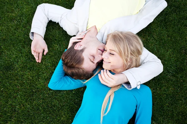 Pareja joven enamorada acostada en la hierba —  Fotos de Stock