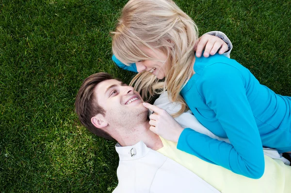 Joven feliz pareja en amor acostado en la hierba —  Fotos de Stock