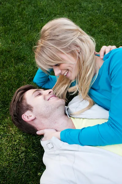 Jovem casal apaixonado deitado na grama — Fotografia de Stock