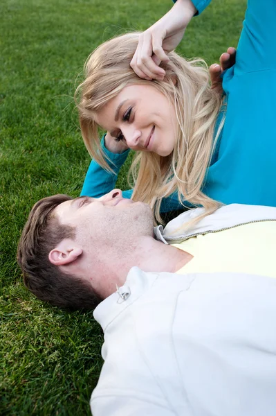 Pareja joven enamorada acostada en la hierba — Foto de Stock