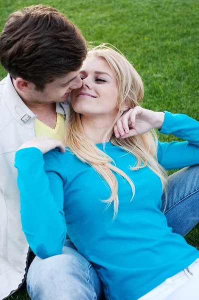 Giovane coppia innamorata seduta in erba — Foto Stock