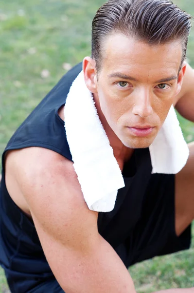 Portrait of a young athletic man with workout towel — Stock Photo, Image