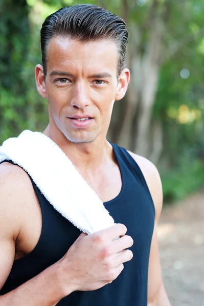 Portret van een jonge atletische man met training handdoek — Stockfoto
