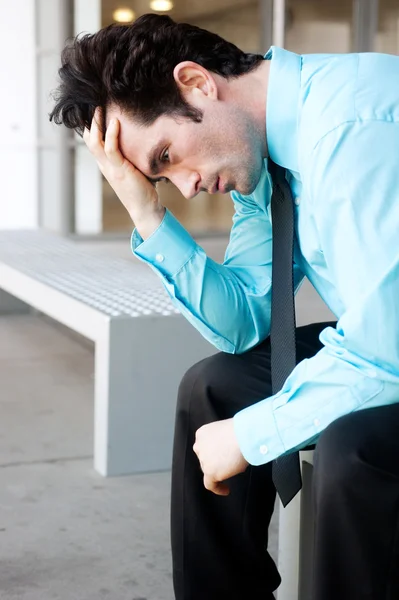 Frustrated businessman sitting on a bench — Stock Photo, Image