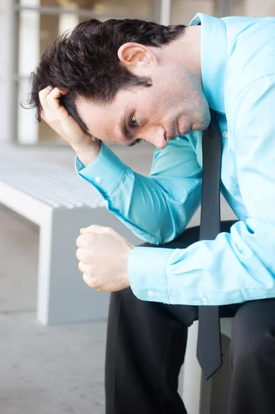 Разочарованный бизнесмен сидит на скамейке — стоковое фото