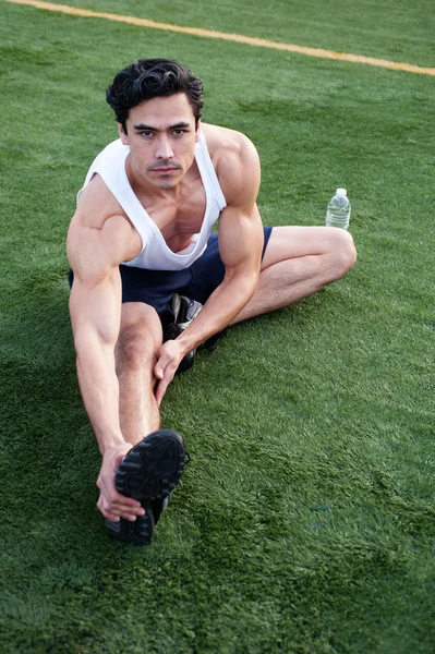 Stilig, unga latino idrottsman stretching — Stockfoto