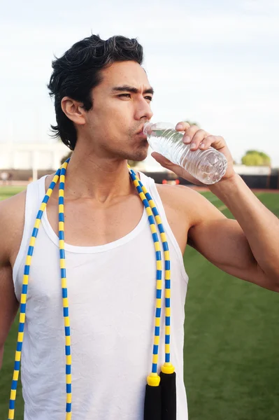Beau, jeune athlète latino eau potable — Photo