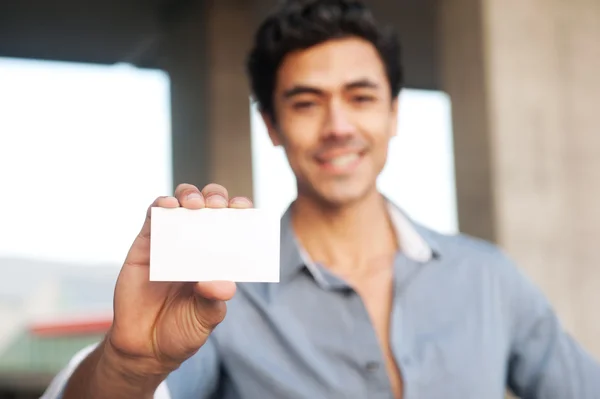 Hombre de negocios guapo presentando tarjeta de visita en blanco — Foto de Stock