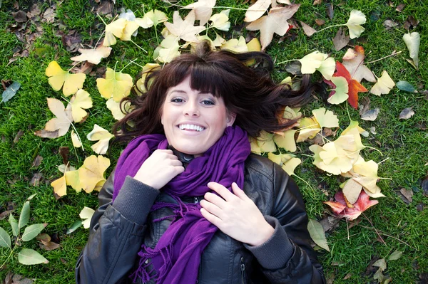 Csinos, fiatal lány feküdt az őszi levelek — Stock Fotó