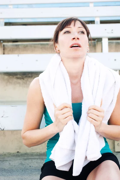 Atleta feminina cansada com toalha — Fotografia de Stock