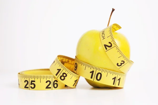 Green apple with yellow measuring tape — Stock Photo, Image