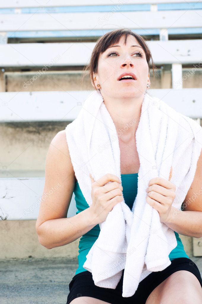 Tired female athlete with towel