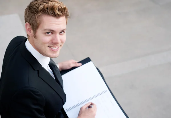 Retrato de un joven empresario feliz con bloc de notas — Foto de Stock