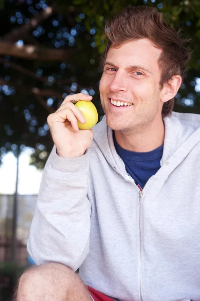 Portrait of a healthy young man holding apple — Stock Photo, Image