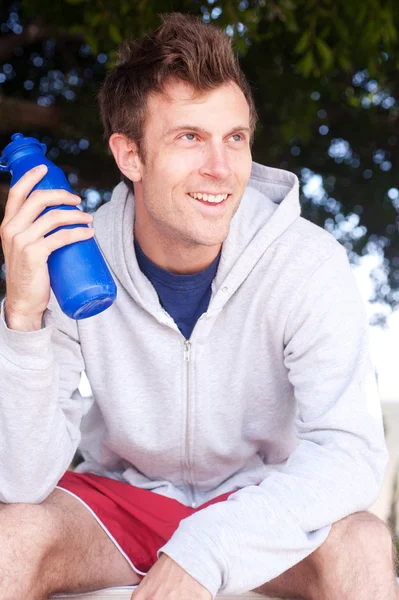 Retrato de um belo jovem atleta com garrafa de água — Fotografia de Stock