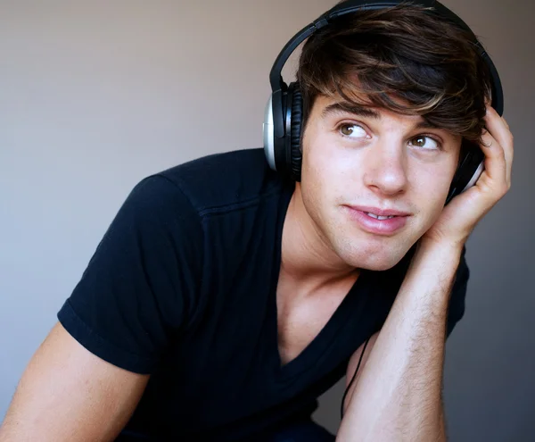 Porträt eines jungen Mannes mit Kopfhörern, der Musik hört — Stockfoto