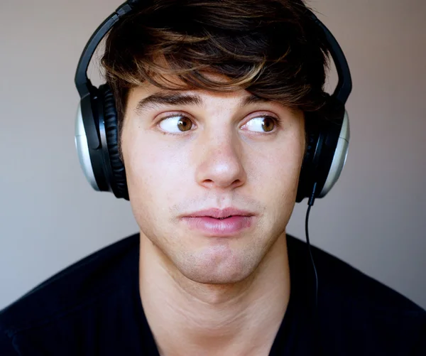 Porträt eines jungen Mannes mit Kopfhörern, der Musik hört — Stockfoto