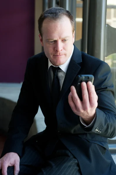 Profi-Geschäftsmann starrt aufs Handy — Stockfoto