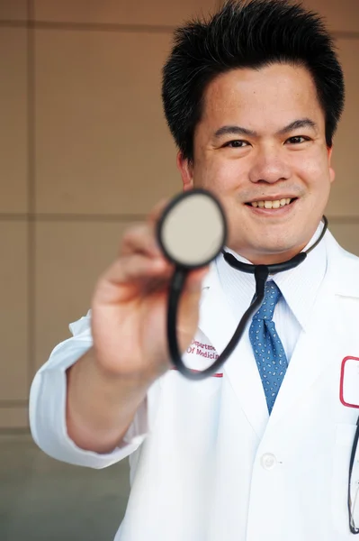 Médico asiático sosteniendo un estetoscopio —  Fotos de Stock