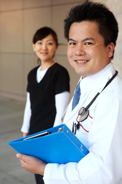 Ασιατικές γιατρός με νοσοκόμα στο παρασκήνιο — Φωτογραφία Αρχείου