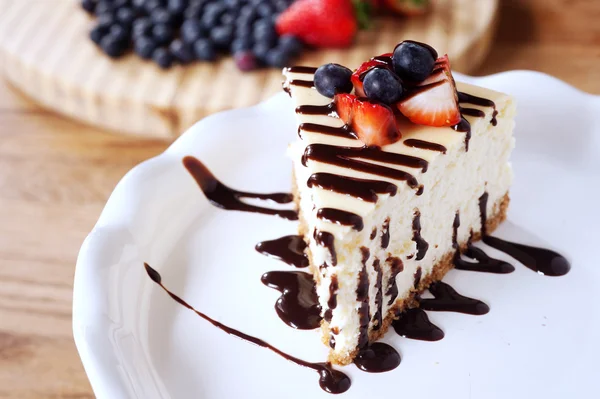 Bit av cheesecake toppat med jordgubbar och blåbär — Stockfoto