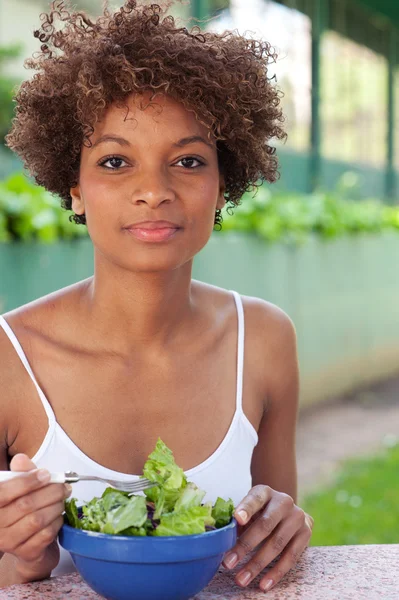 Jolie femme afro-américaine mangeant une salade — Photo