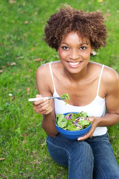 Dość african american kobieta jedzenie sałatka — Zdjęcie stockowe