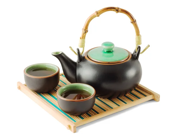 stock image Brown teapot and teacups on the wooden trivet