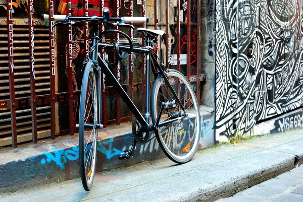 Egy fekete kerékpár és városi graffiti Melbourne-ben — Stock Fotó
