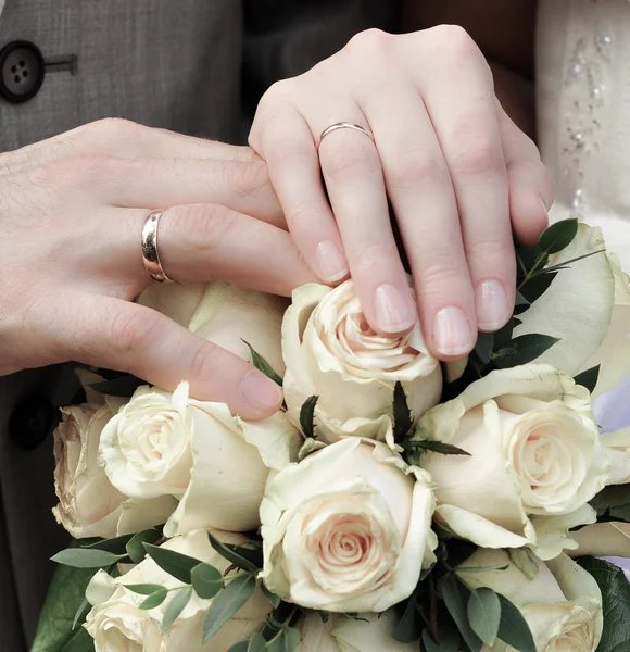 stock image Hands of newlywed couple with bouquet