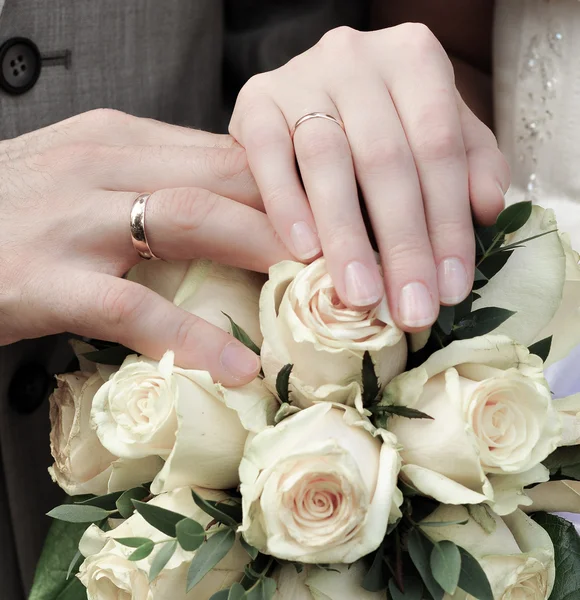 Hände des Brautpaares mit Blumenstrauß Stockfoto