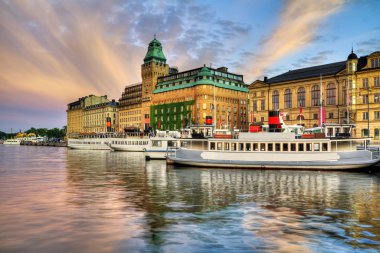 Old ships and beautiful sunset in Stockholm. clipart