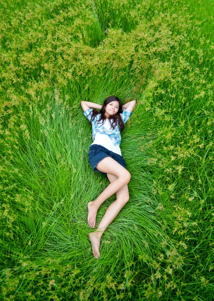 草原に横たわってかわいいアジアガール — ストック写真