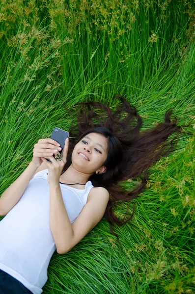 Asiatische Niedlich Mädchen SMS auf Wiese — Stockfoto