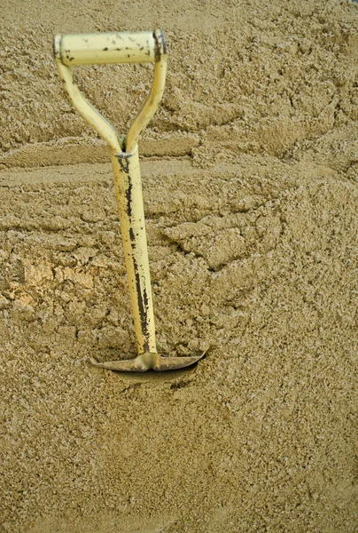 Желтая лопата на песке — стоковое фото