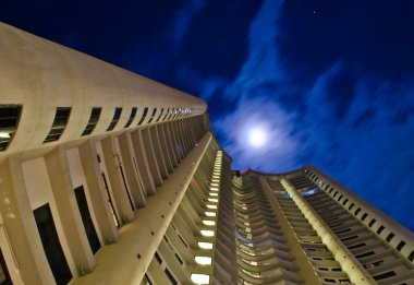 Worm's eye view of a condo in the middle of the night clipart