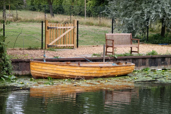 Маленькая лодка и скамейка — стоковое фото