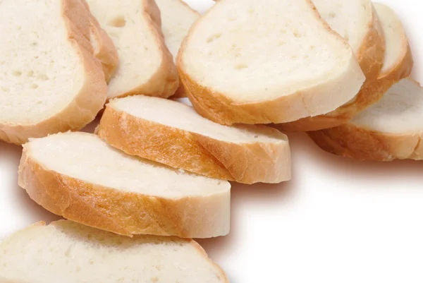 Длинная буханка белого хлеба, разрезанная на куски — стоковое фото