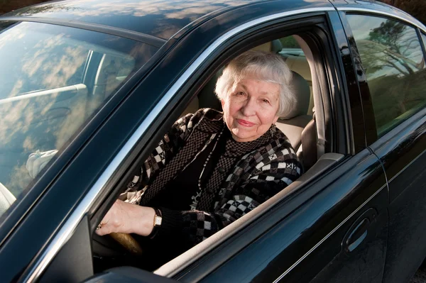 그녀의 집, drivingn에서 86 세의 여성이 그녀의 차 스톡 사진