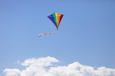 Colored kite floating in the sky clipart