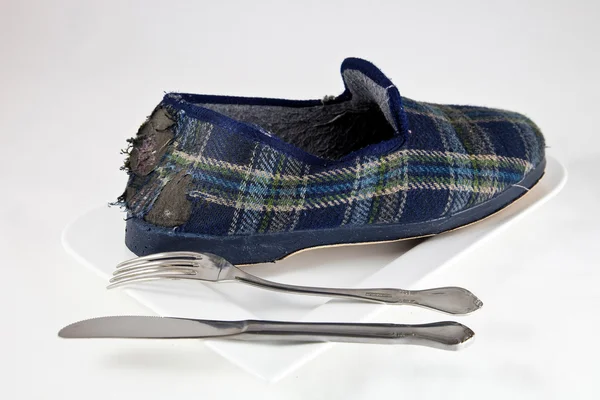Zapato de tela en plato con utensilios de cocina —  Fotos de Stock