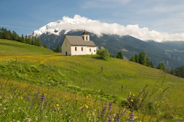 Церковь в альпийском пейзаже — стоковое фото