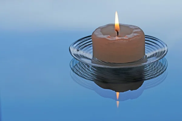 stock image Lovely lit candle on little glass