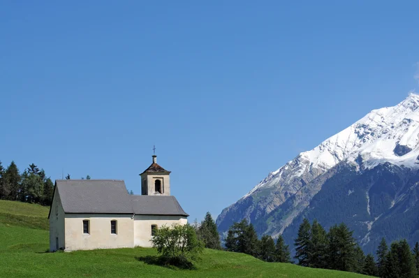Picturesque landscape featuring a a church in the swiss alps — Stock Photo, Image