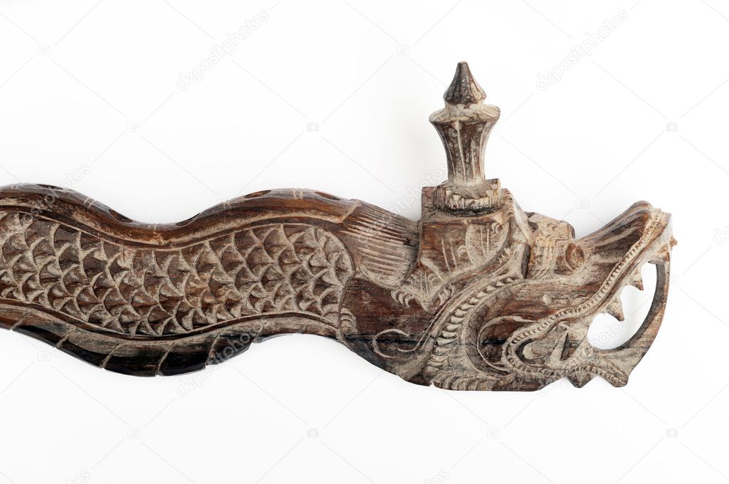 Close-up of an oriental wooden flute carved in the shape of a dragon against white background