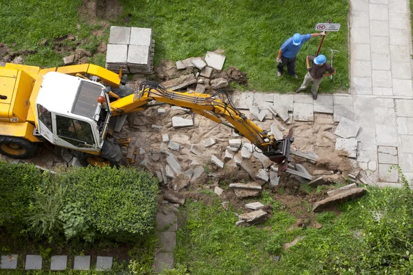 Excavator vigorously destroys old pavemen — Stock Photo, Image