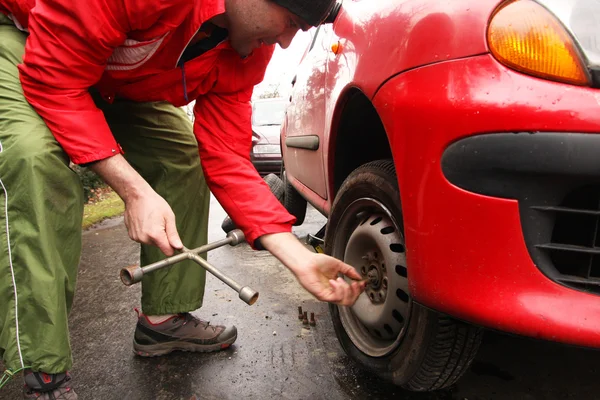 Άνθρωπος να αλλάξεις λάστιχο στο αυτοκίνητο στο δρόμο — Φωτογραφία Αρχείου